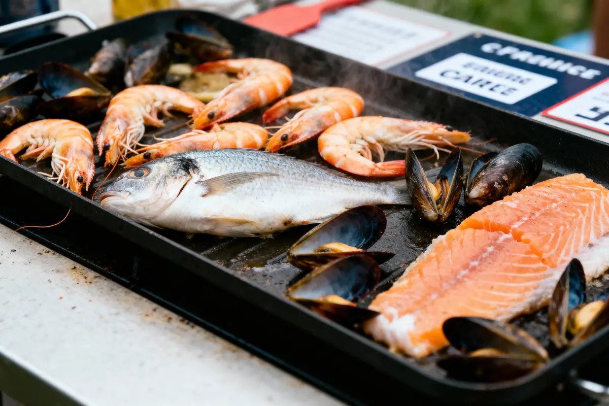pexels-michal-pech-213601-757318 (1) Poisson, crevettes, moules et saumon cuisent sur une plancha.