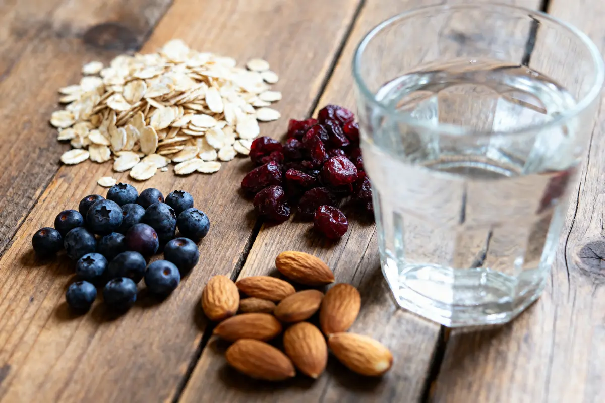 Verre d'eau, flocons d'avoine, amandes, myrtilles et canneberges aliments qui calment les hémorroïdes