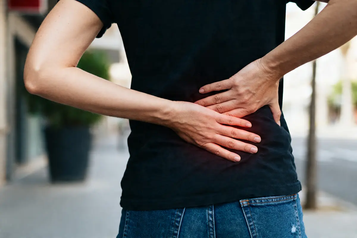 Personne touchant son bas du dos souffrant de douleur en bas du ventre et du dos