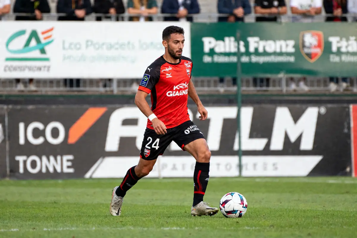 Joueur de foot en action sur le terrain lors d'un match de sport en r