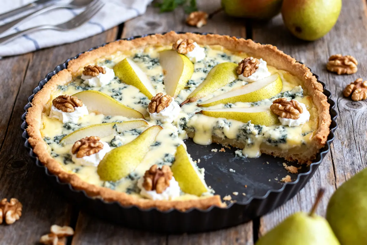 Tarte au roquefort et aux poires garnie de noix dans un moule noir